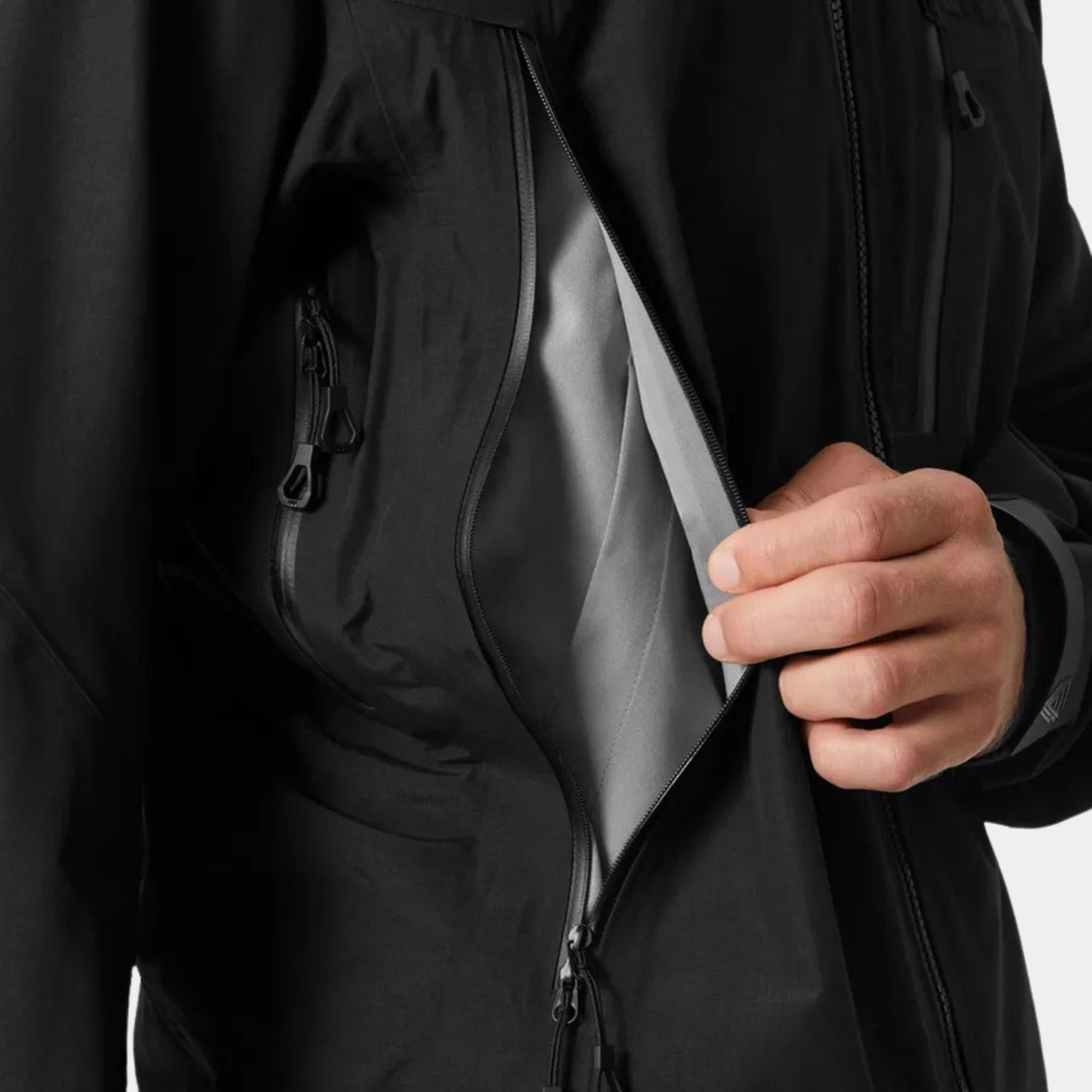 Close up of a male model opening a pocket on the Helly Hansen Odin 9 Worlds 3.0 Hard Shell Jacket in Black