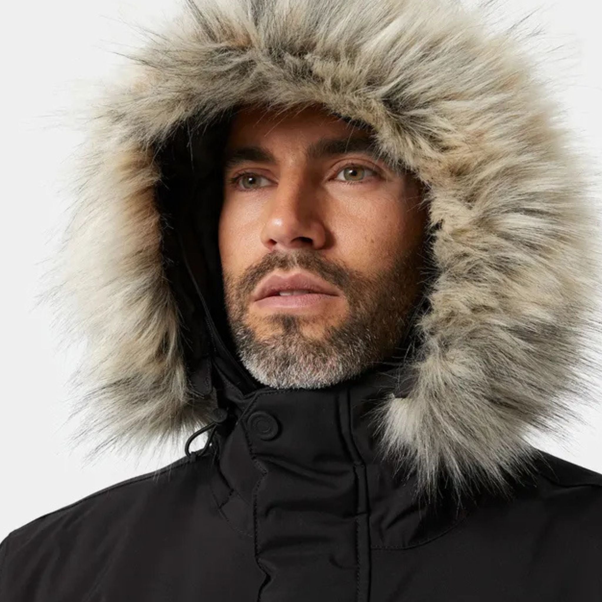 Male model showing the hood on a black Helly Hansen Reine Parka