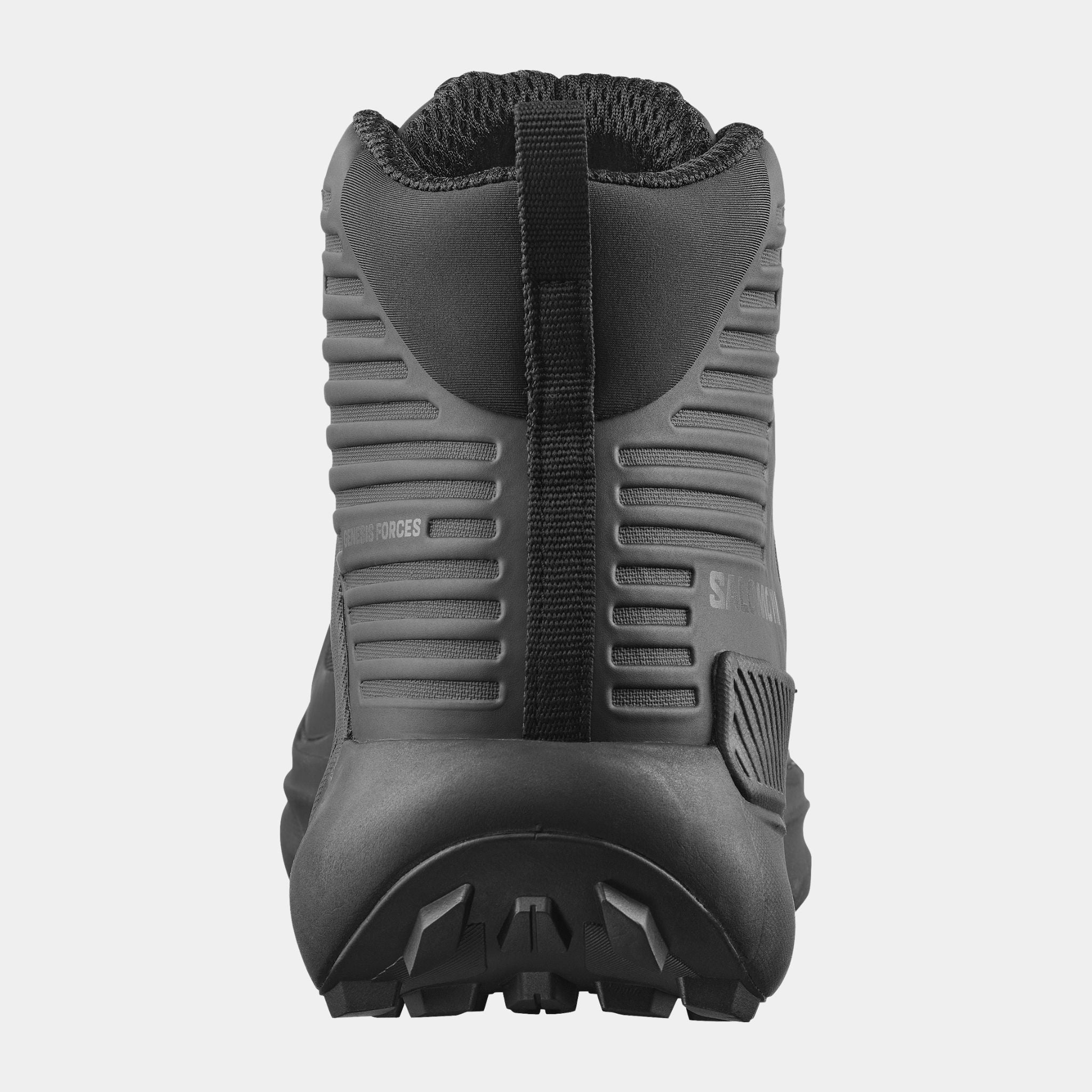 A Salomon Genesis boot shown from the rear three-quarter view, featuring a textured ribbed side panel, a vertical black heel pull tab, and a rugged black sole, set against a plain light gray background.