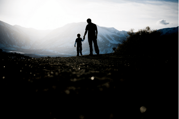 father and son standing on a hill